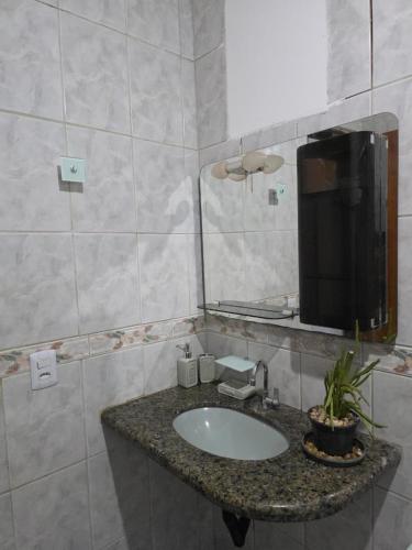 a bathroom with a sink and a mirror at Jardim Primavera in Palmas