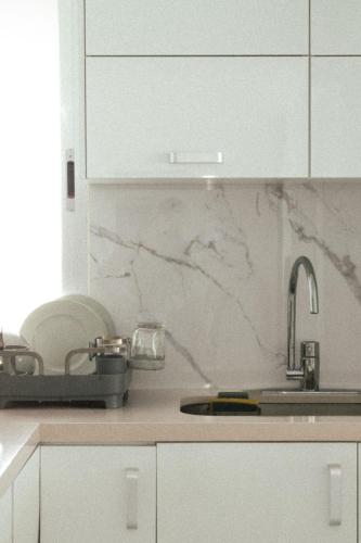 a kitchen with white cabinets and a sink at Naia Mar in Cancún