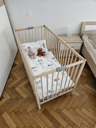 a crib with two stuffed animals in a bedroom at Schlossbergblick in Bruck an der Mur
