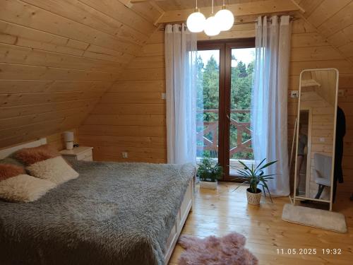 DomaniewiceにあるJura - Chata pod Grodziskiem Pańskimのベッドと大きな窓のある寝室