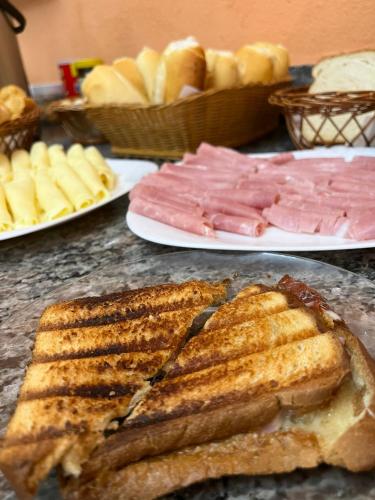 un tavolo sormontato da piatti di carne e pane di Pousada Bela Vista do Ismail - Lapinha da Serra a Santana do Riacho