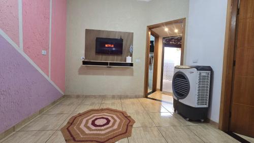 a hallway with a room with a heater and a television at Casa aconchegante 4 minutos do thermas in Andradina