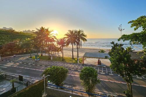 Blick auf einen Strand mit Palmen und das Meer in der Unterkunft 25C - Pé na Areia do Tombo, 1 Suite Master, Ar Cond, 2Wc, 1 vaga, Roupa de Cama e Vivo fibra in Guarujá