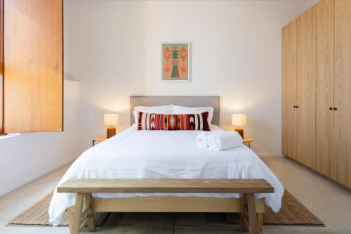 a bedroom with a large white bed and two lamps at Outsite Oaxaca City - Work, Connect, Explore in Oaxaca City