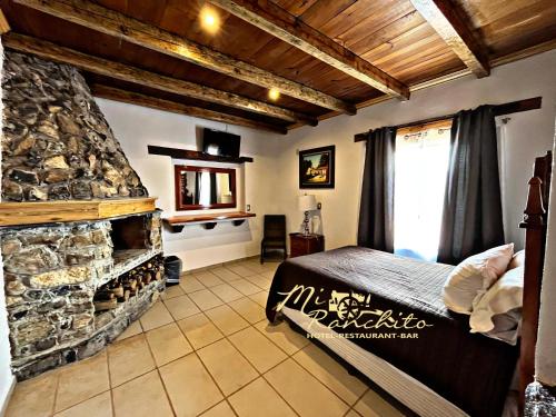 a bedroom with a fireplace and a bed in a room at Mi Ranchito Chignahuapan Hotel in Chignahuapan