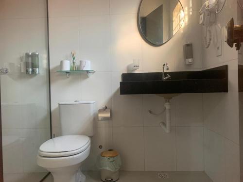 a bathroom with a toilet and a sink and a mirror at The Riverside in Novo Acordo