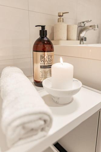 a bottle of soap and a candle on a bathroom counter at Aurora Suite, Rovaniemi city center in Rovaniemi