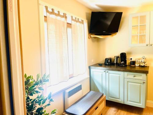 a kitchen with a window and a bench next to a table at cosy studio dans une maison d'hôte in Bourg-en-Bresse