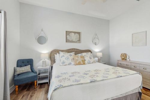 een slaapkamer met een bed en een blauwe stoel bij Breezy Cottage in Rockport