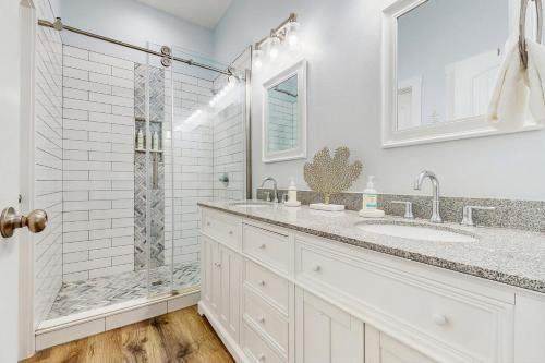 een witte badkamer met douche en wastafel bij Breezy Cottage in Rockport