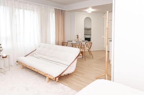 a white living room with a couch and a table at Aurora Suite, Rovaniemi city center in Rovaniemi