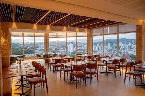 ein Restaurant mit Tischen und Stühlen mit Aussicht in der Unterkunft Monthez Hotel & Eventos in Brusque