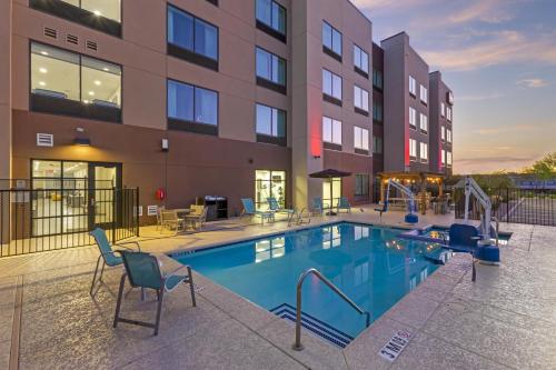 a pool with chairs and a slide in front of a building at Best Western Plus Executive Residency Phoenix North Happy Valley in Phoenix