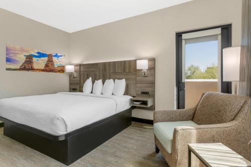 a hotel room with a bed and a chair at Best Western Plus Executive Residency Phoenix North Happy Valley in Phoenix