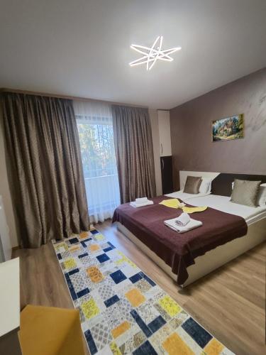 a bedroom with a large bed and a chandelier at Madini apartment in Velingrad