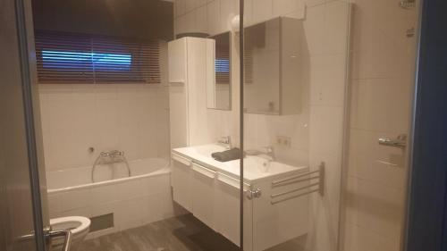 ブラスカートにあるBeach Houseのシャワー、洗面台、浴槽を備えたバスルーム