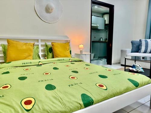 a bed with a green comforter with flowers on it at Maankhool Sleep 3 in Dubai