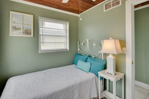 une chambre avec un lit et une lampe sur une table dans l'établissement Cozy Ormond Beach Bungalow Steps to the Sand, à Ormond Beach