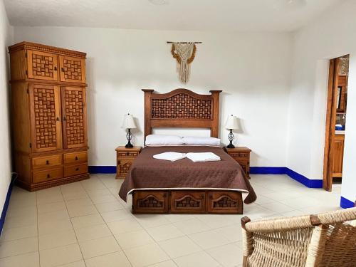 ein Schlafzimmer mit einem Bett mit zwei Nachttischen und zwei Lampen in der Unterkunft El Encino in Tepoztlán