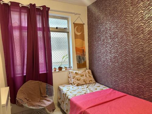 a bedroom with a bed and a window and a chair at A breath of fresh air in Belém in Belém