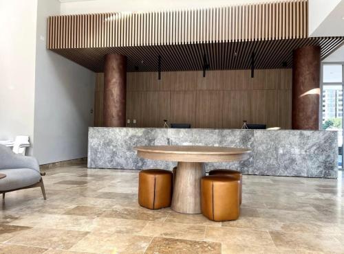 a lobby with a table and two stools and a counter at Aparta Suite en Santamarina - Escápate al Caribe in Santa Marta