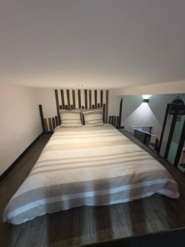 a bedroom with a large bed with white sheets at Le Cocoon Provençal - à deux pas de la mairie in Aix-en-Provence