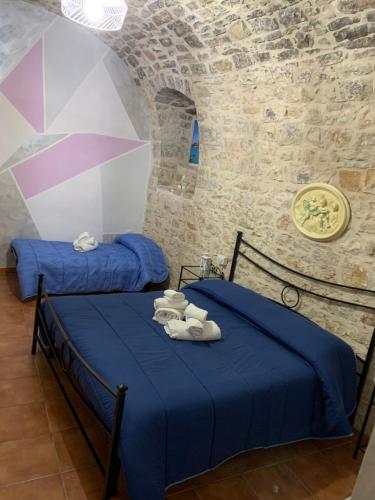 two beds in a room with blue sheets and towels at Marisol al puerto in Molfetta