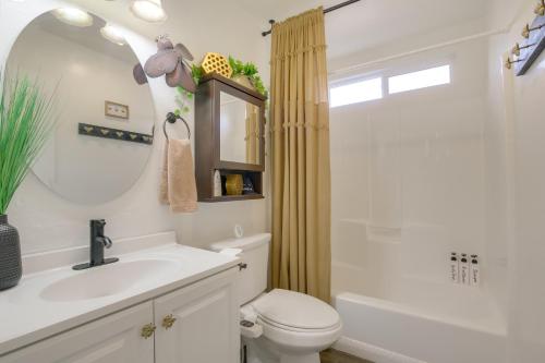 ein Badezimmer mit Waschbecken, Toilette und Spiegel in der Unterkunft Big Bear Ski Hideaway! Cozy Cabin with Fenced Yard in Big Bear City Airport