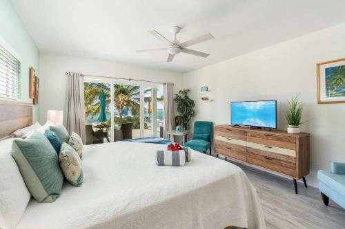 a bedroom with a large bed and a television at The Tropical Breeze Cottage in Sand Bluff