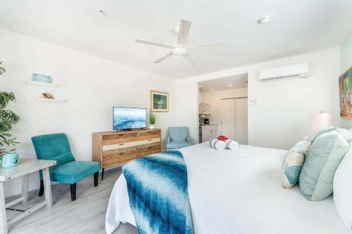 ein Schlafzimmer mit einem Bett und einem Schreibtisch und Stühlen in der Unterkunft The Tropical Breeze Cottage in Sand Bluff