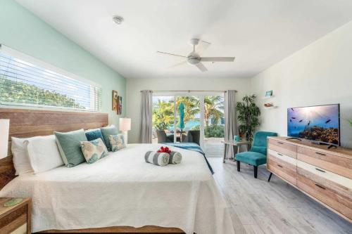 ein Schlafzimmer mit einem großen Bett und einem Deckenventilator in der Unterkunft The Tropical Breeze Cottage in Sand Bluff