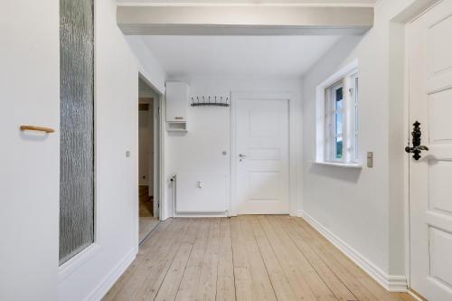 an empty hallway with white walls and wood floors at Annexgården 9A in Tommerup