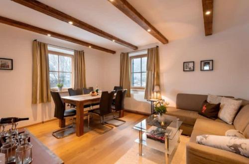 a living room with a couch and a table and chairs at Haus Huber Sonnenhofweg in Kitzbühel
