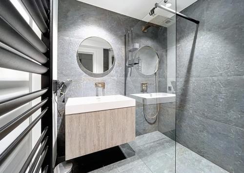 een badkamer met een wastafel en een spiegel bij Apartment Sunset Koksijde in Koksijde