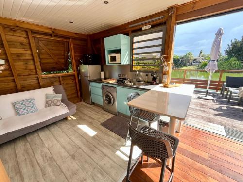 a kitchen and living room with a table and chairs at BUNGA-LODGE (bungalow 4* avec piscine privée) in Douville