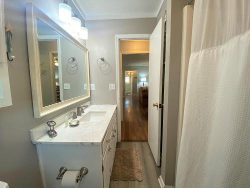 a bathroom with two sinks and a large mirror at Sand In My Shoes in Edisto Island