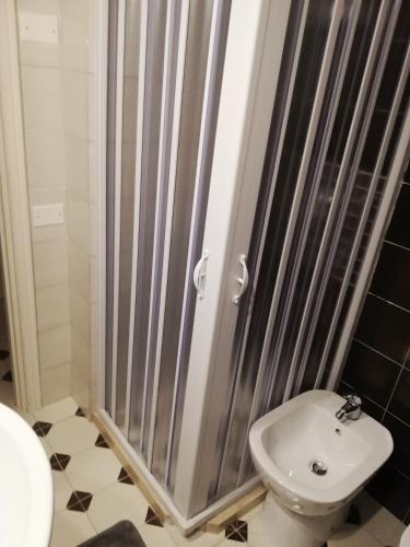 a bathroom with a shower with a toilet and a sink at Sunset House in Santa Marinella