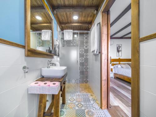 une salle de bain avec lavabo et une chambre dans l'établissement Alanacasarural, à Mondéjar
