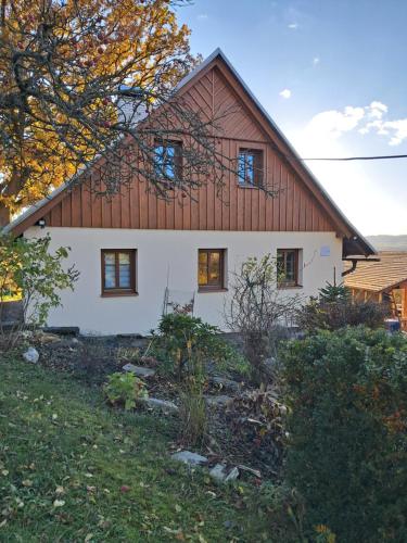 a large white house with a wooden roof at Apartmán v podhůří Jizerských hor in Železný Brod