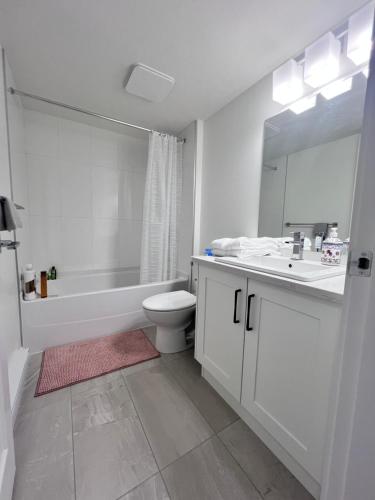 a white bathroom with a tub and a toilet and a sink at Kris Anclam in Langley