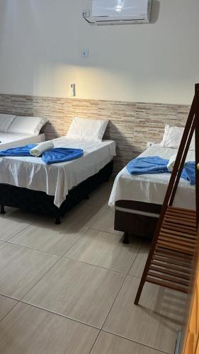 two twin beds in a room with a staircase at Hotel Raio do Sol in Ibicoara