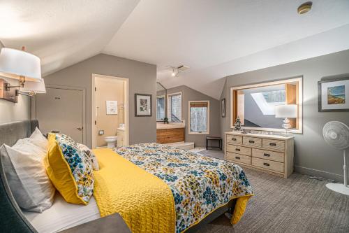 a bedroom with a yellow bed and a sink at Wintergreen Condo, Unit #543 in Thompsonville