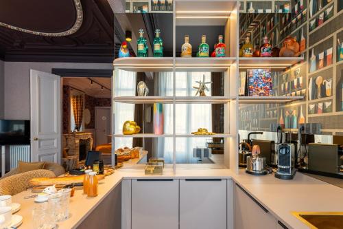 a kitchen with a counter with many bottles on the shelves at Villa Emilia - Suites de prestige au coeur de Nancy in Nancy