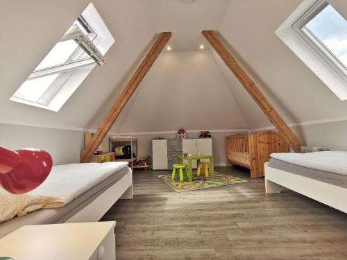 a attic bedroom with two beds and skylights at Wohnung 60 in Horumersiel