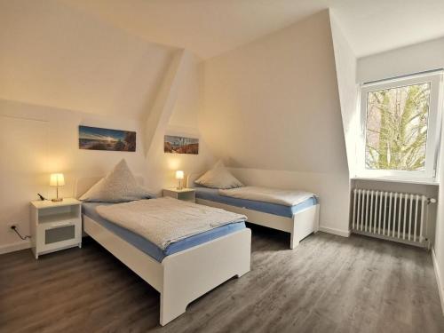 a bedroom with two beds and a window at Wohnung 60 in Horumersiel