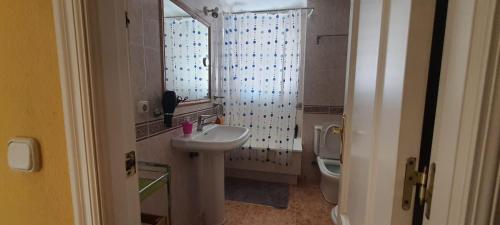 a small bathroom with a sink and a toilet at Rooms Tourist Apartment in Huelva