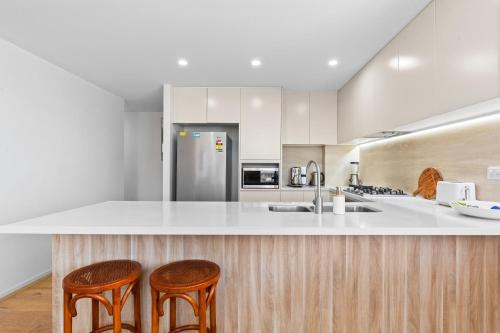 a kitchen with two stools and a counter top at Seaside Retreat with Parking and Balcony in Newport