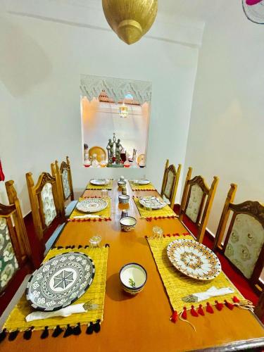a dining room table with plates and dishes on it at Blue Star Hostel in Fez