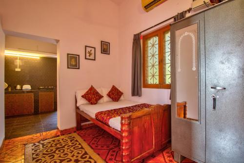 a bedroom with a bed and a window and a door at Anjuna House With Ocean View in Anjuna