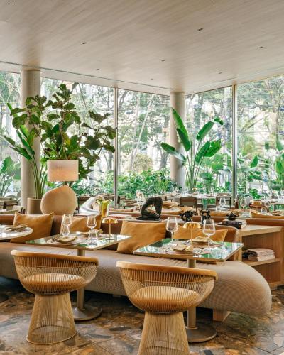 a restaurant with tables and chairs and large windows at Pulso Hotel Faria Lima in São Paulo
